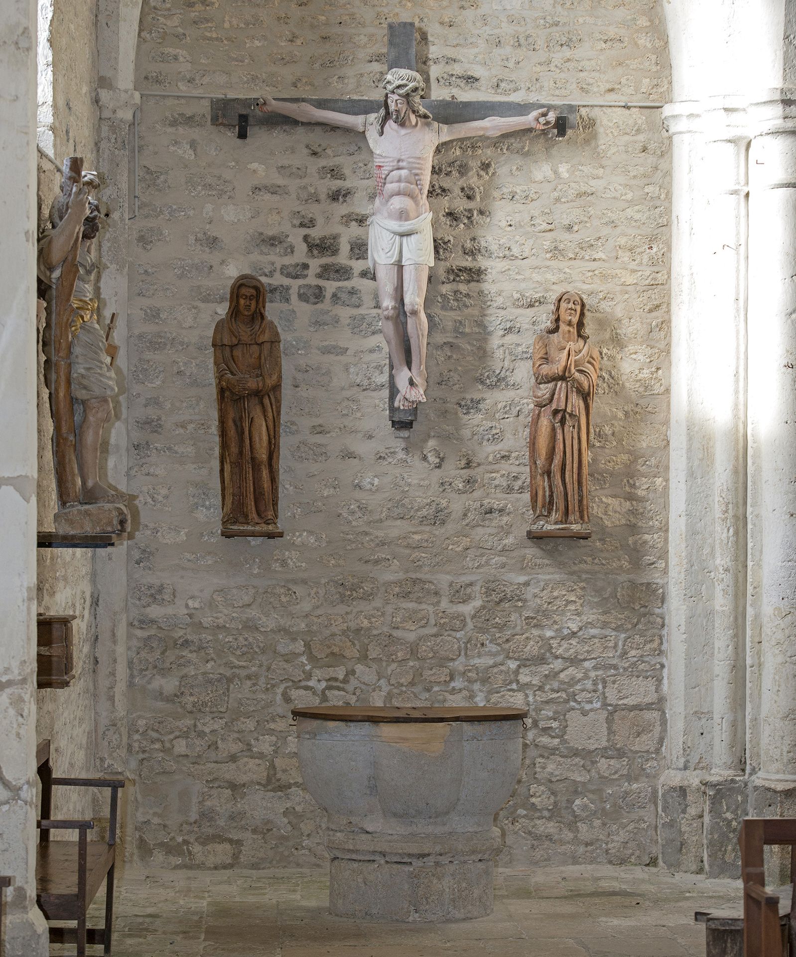 Le christ entouré à gauche de Marie et à droite de Jean. Au dessous les fonts baptismaux et à gauche sur l'autre mur un saint Christophe.